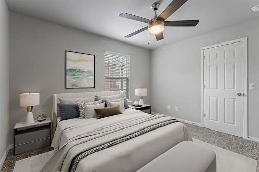 A bedroom with a large bed and a ceiling fan.