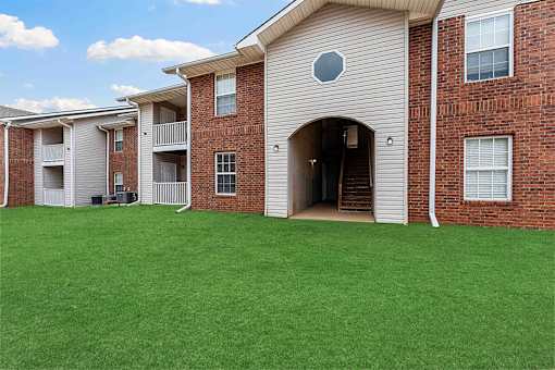A large house with a green lawn in front.