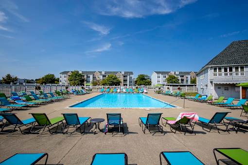 A large swimming pool surrounded by lawn chairs.