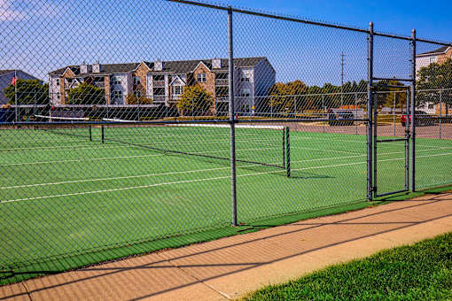 A tennis court surrounded by a fence.
