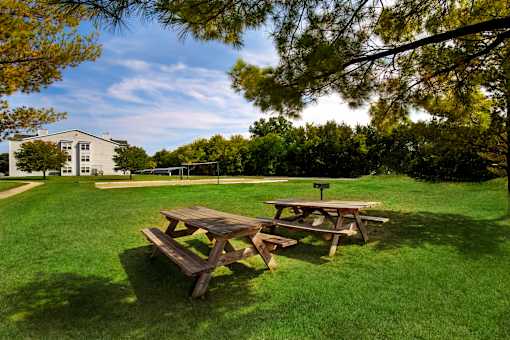 A picnic table sits in a grassy field.