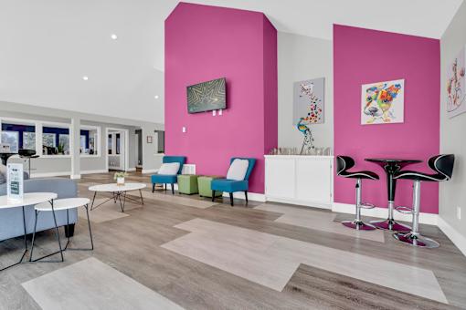 A brightly colored room with a pink wall and a white table.