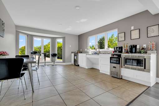 A kitchen with a black chair and a white counter.