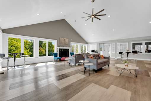 A spacious living room with a grey sofa and a wooden floor.