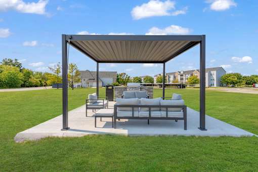 A white couch is on a patio under a canopy.