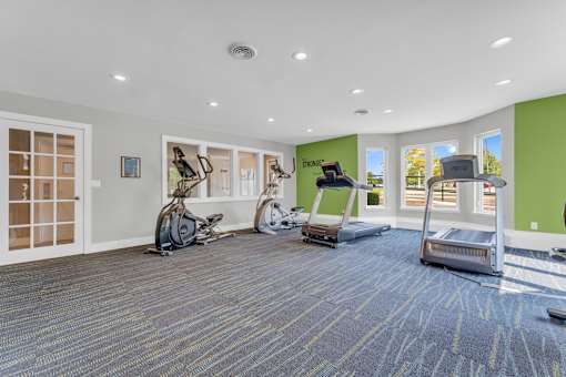 A room with a green wall and exercise equipment.