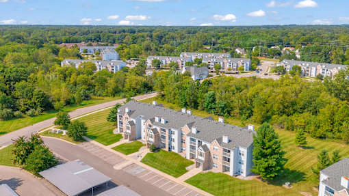 A large building complex with a parking lot in front.