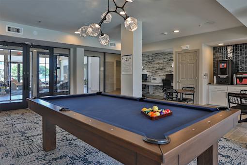 A pool table with a blue cloth and a set of balls on it.