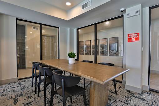 A conference room with a long table and chairs.