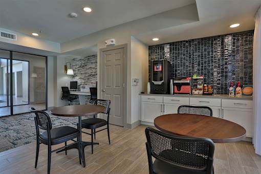 A kitchen with a table and chairs in front of a wall with a stone pattern.