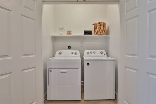 A white laundry room with a washer and dryer.