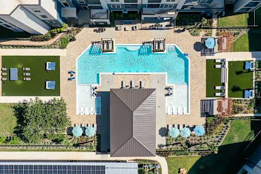 A swimming pool surrounded by a deck and a pavilion.