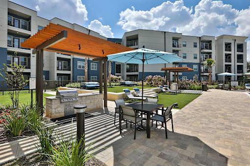 A patio with a table and chairs is surrounded by apartment buildings.