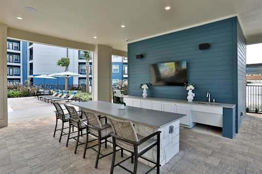 A patio with a bar and chairs.