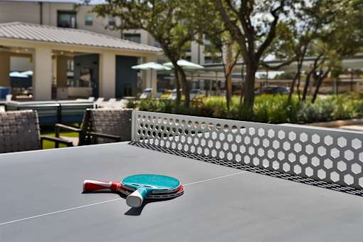 A red and green paddle is on a table tennis table.