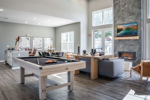 a living room with a pool table and a fireplace
