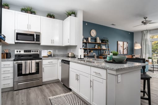 a kitchen with white cabinets and stainless steel appliances