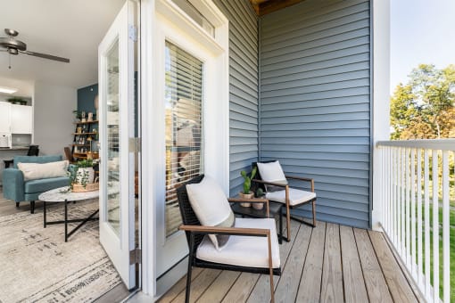 a porch with two chairs and a sliding glass door