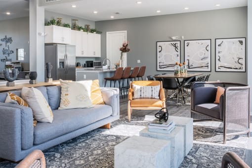 a living room and kitchen with a couch and chairs