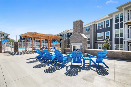 our apartments have a large patio with blue chairs and a fire pit