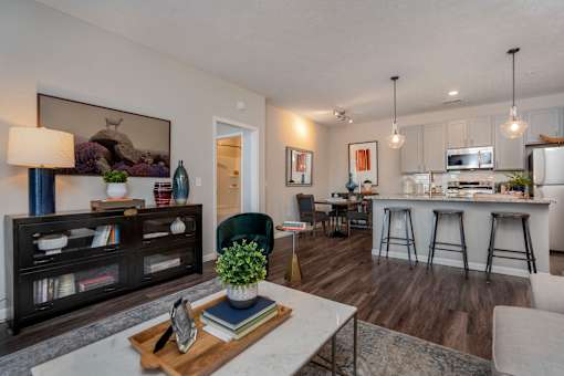 A modern living room with a bar area and kitchen in the background.