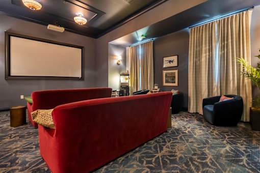 A room with a red couch and a whiteboard on the wall.