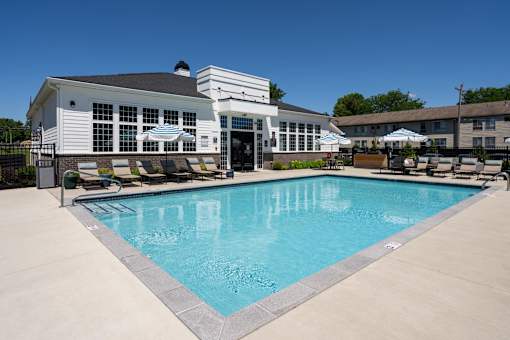 A large swimming pool in front of a white building.