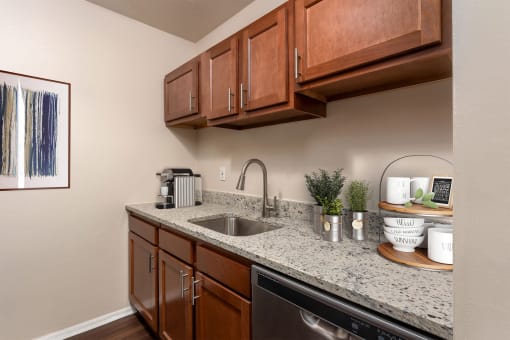 a kitchen with granite counter tops and wooden cabinets