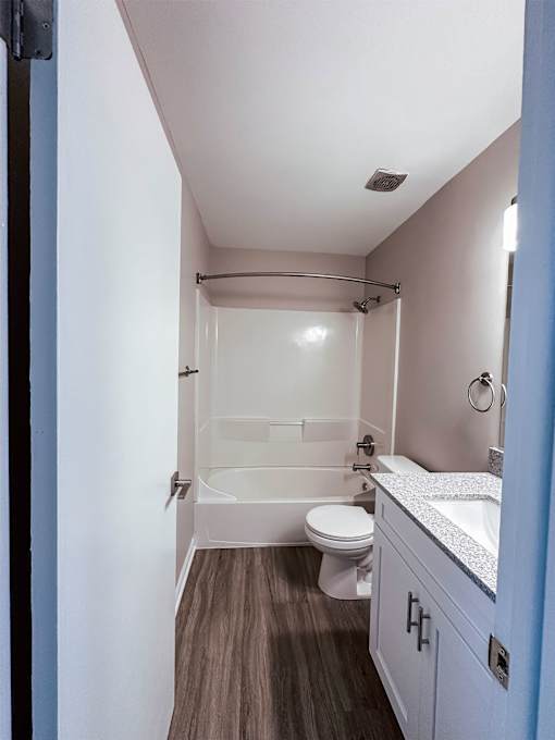 A small bathroom with a toilet, sink and shower.