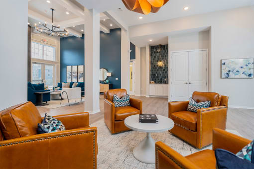 apartment community clubhouse with brown leather chairs and round coffee table