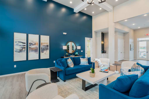 clubhouse with blue sofas gray chairs and art on the wall