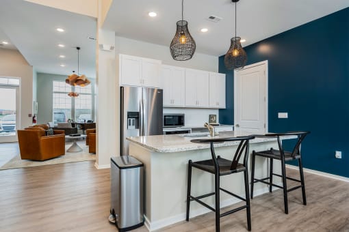 apartment clubhouse kitchen with island barstools and stainless steel fridge