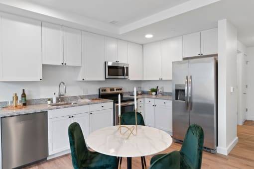 a kitchen with white cabinets and stainless steel appliances and a round table