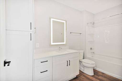 A white bathroom with a toilet, sink, and bathtub.