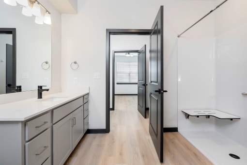 bathroom with sink and shower with bench