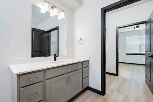 a white bathroom with a large mirror and a sink