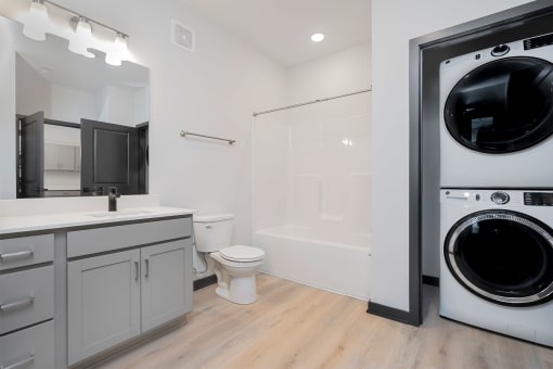 bathroom with a tub and washer and dryer