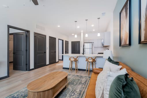 living room with sofa and coffee table and the kitchen in the background