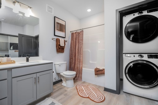 bathroom with a tub and a washer and dryer