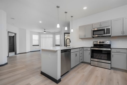 a large kitchen with white cabinets and stainless steel appliances