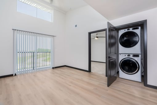 apartment living room with balcony sliding door and a washer and dryer