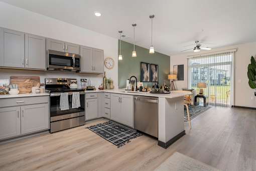 A kitchen with a wooden floor and stainless steel appliances.