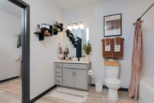 A bathroom with a white toilet and a white bathtub.