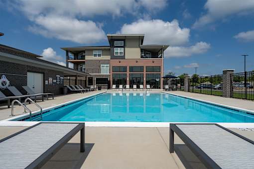 A large swimming pool in front of a multi-story building.