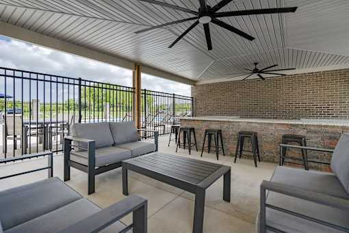 A patio with a table, chairs, and a ceiling fan.