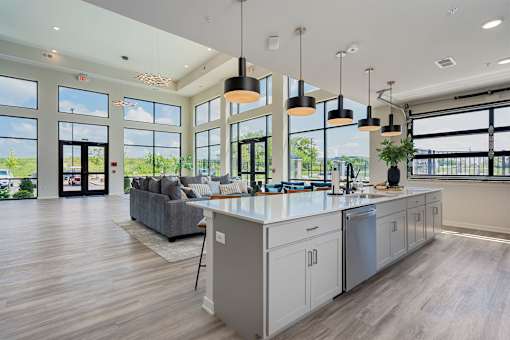 A modern kitchen with a large island and pendant lights.