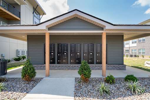 A modern house with a grey front and a black mailbox.
