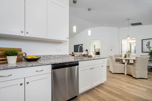 a kitchen with white cabinets and a stainless steel dishwasher