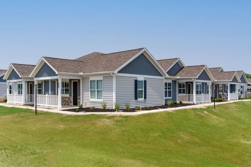 a row of manufactured homes on a lush green lawn