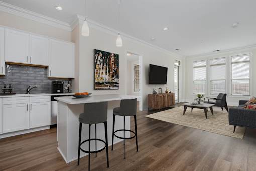 A modern kitchen with white cabinets and a wooden island.